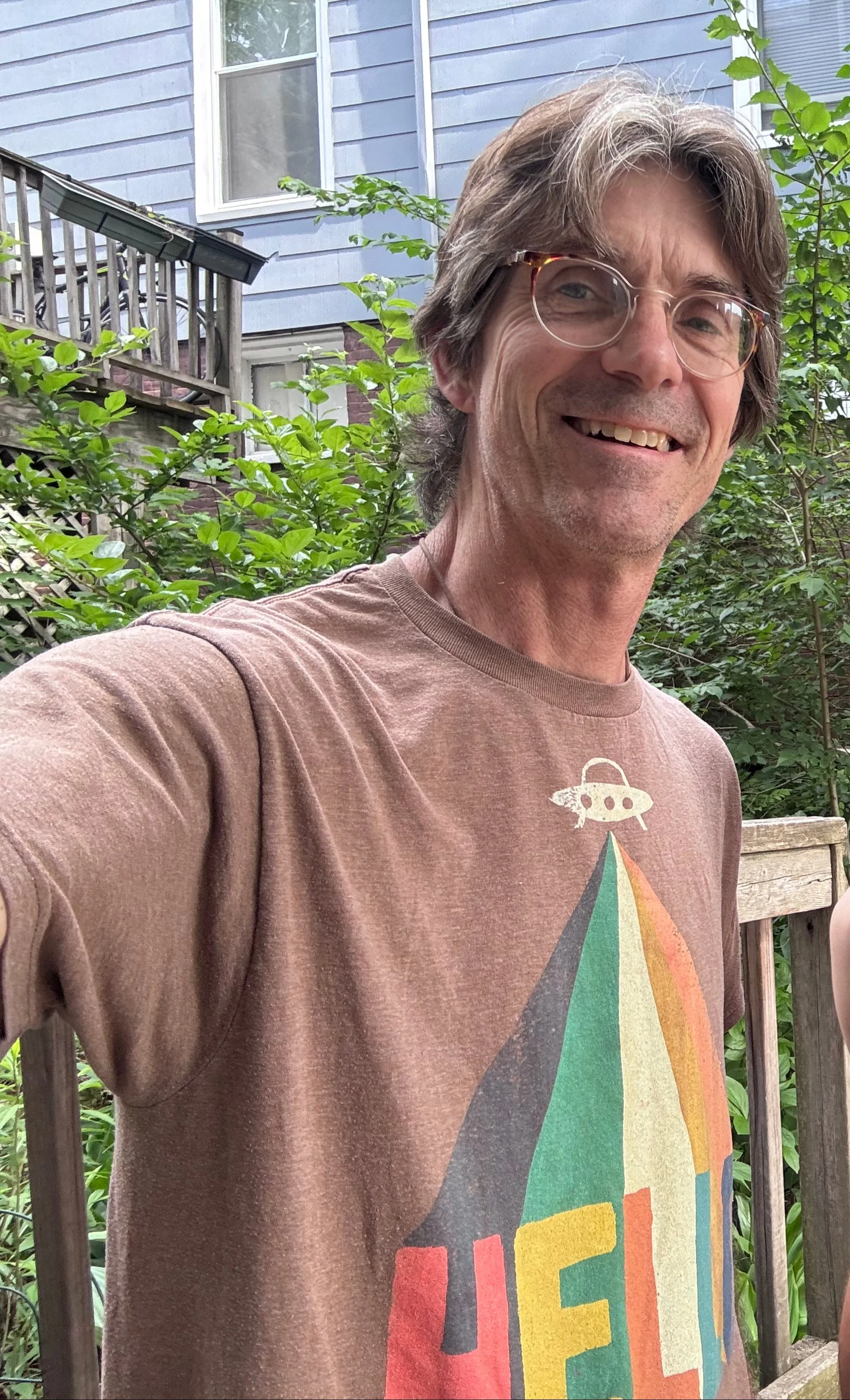 Matthew Alcorn smiling outdoors beside a house.