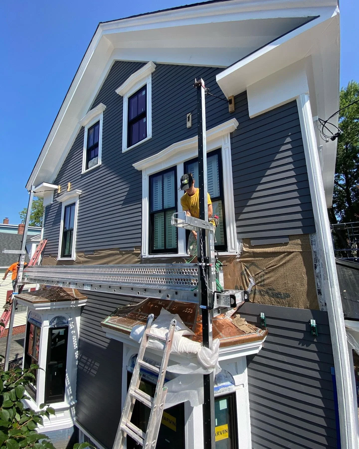 Blue house exterior with white trim and front-porch renovation work.