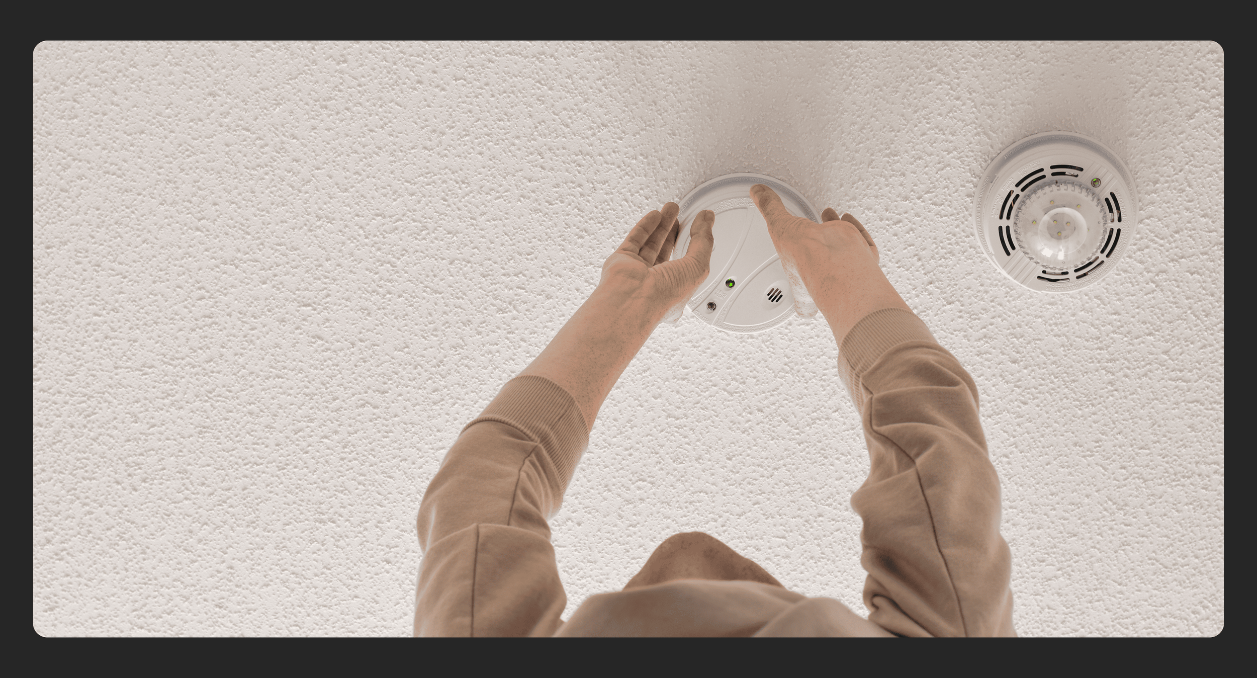 homeowner changing smoke alarms