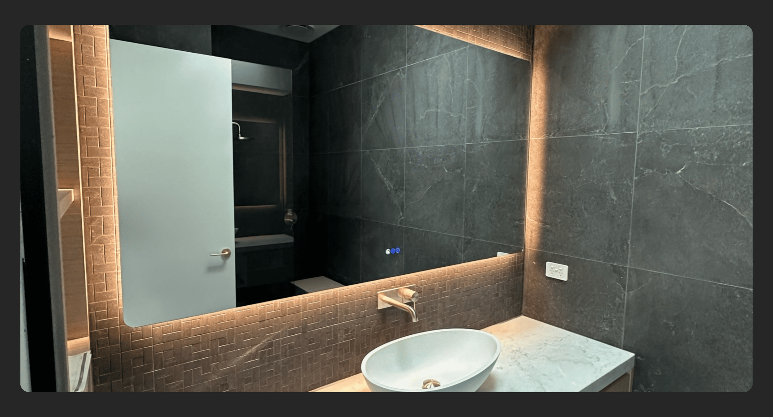 bathroom lit up with warm LED lighting behind mirror