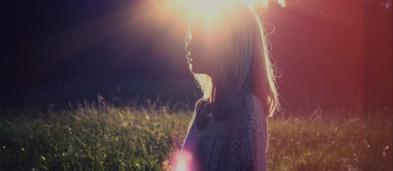 woman+stanidng+in+field+with+sun+flare+behind+head-min.jpg