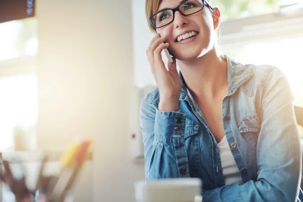 Woman sitting at table talking on a cell phone