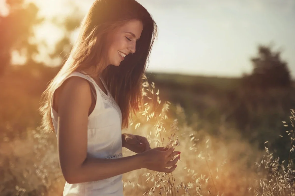 Woman standing in field looking happy