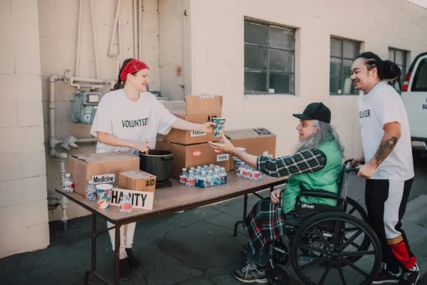 Woman passing out a drink to person in wheelchair at charity event