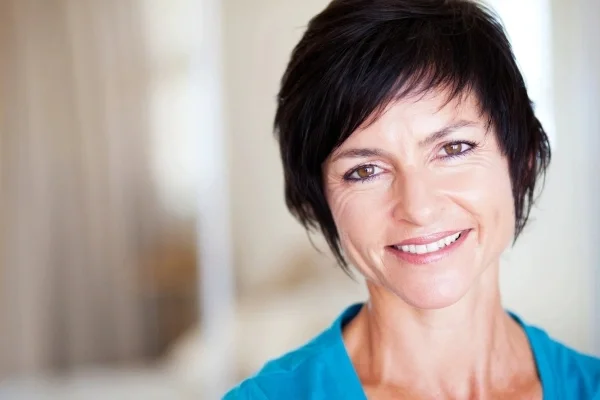 Woman with short dark hair smiling looking at the camera