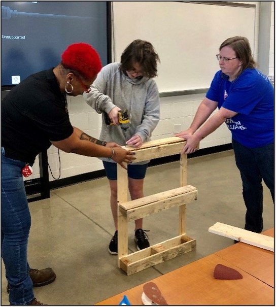  Altenese Hawkins shows a SHE BUILDER how to use tools  