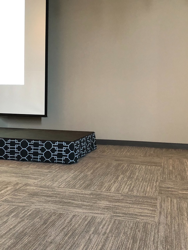 Seminar Room at the Boston Design Center using gray carpet tiles, gray painted walls, a version of Hale Navy and Decorators White on the platform skirt.