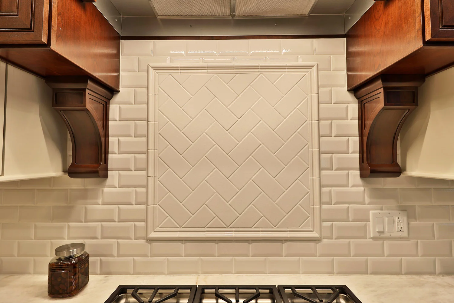 The cooktop backsplash has a flat subway tile in 3" x 6" herringbone pattern backsplash and chair rail molding border.