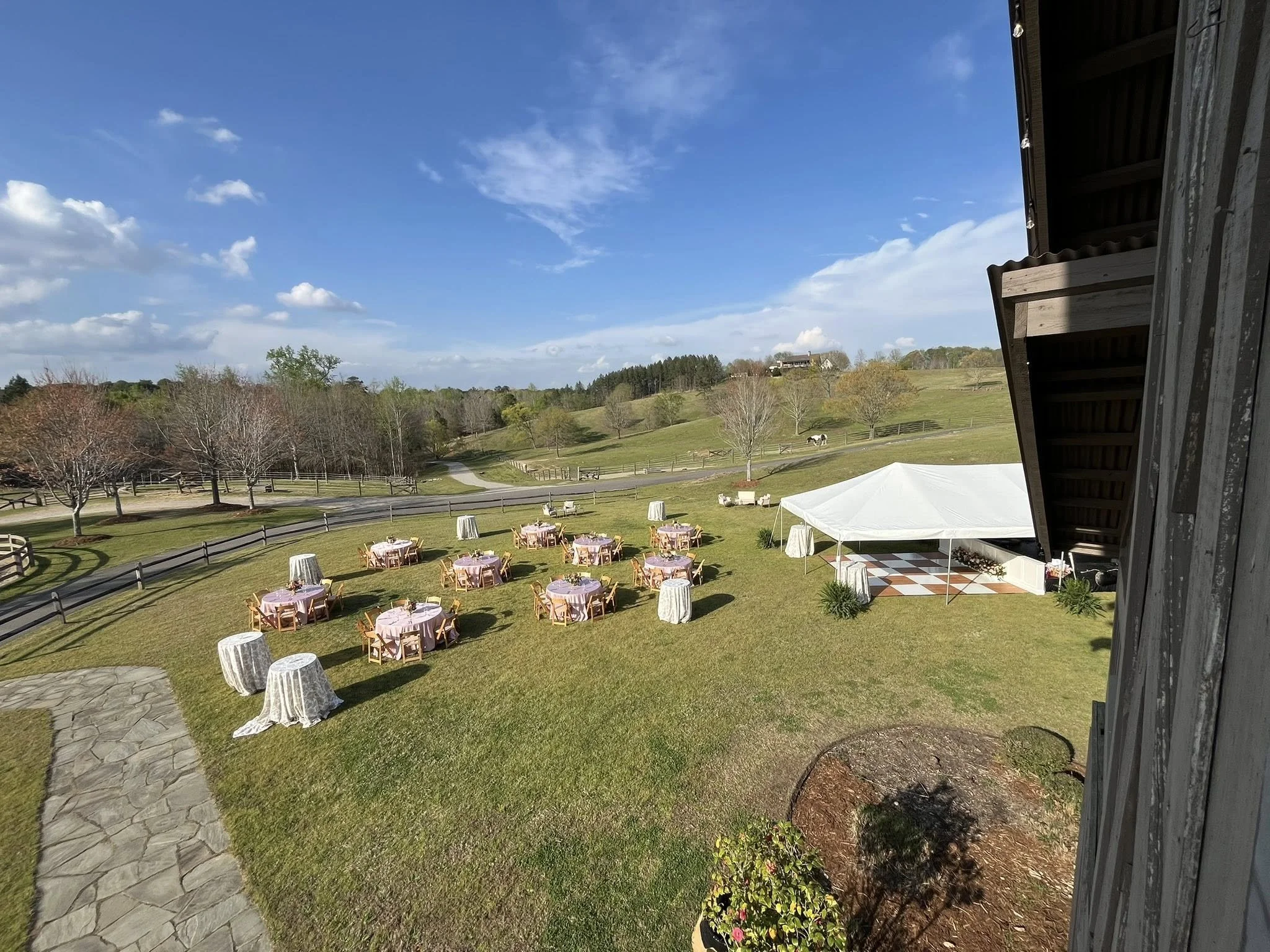 Rustic wedding reception at The Stables at Russele Crossroads near Lake Martin Alabama with wood beams, equestrian details, and elegant event design.