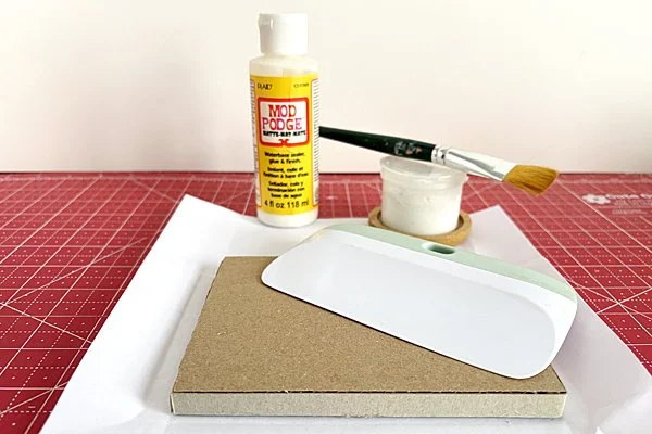 putz house cardboard sandwich with paper, diluted Tacky Glue, paintbrush and smoothing tool.