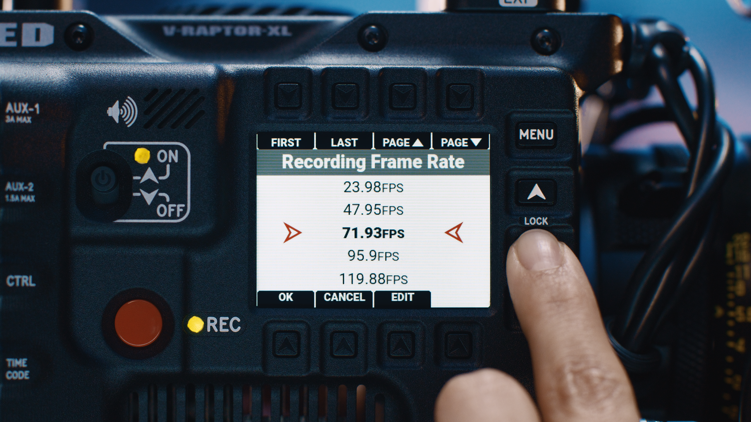A camera's display screen shows recording frame rates in FPS, with current rate at 71.93 FPS. The camera is held by a person's hand and is surrounded by various control buttons and dials.