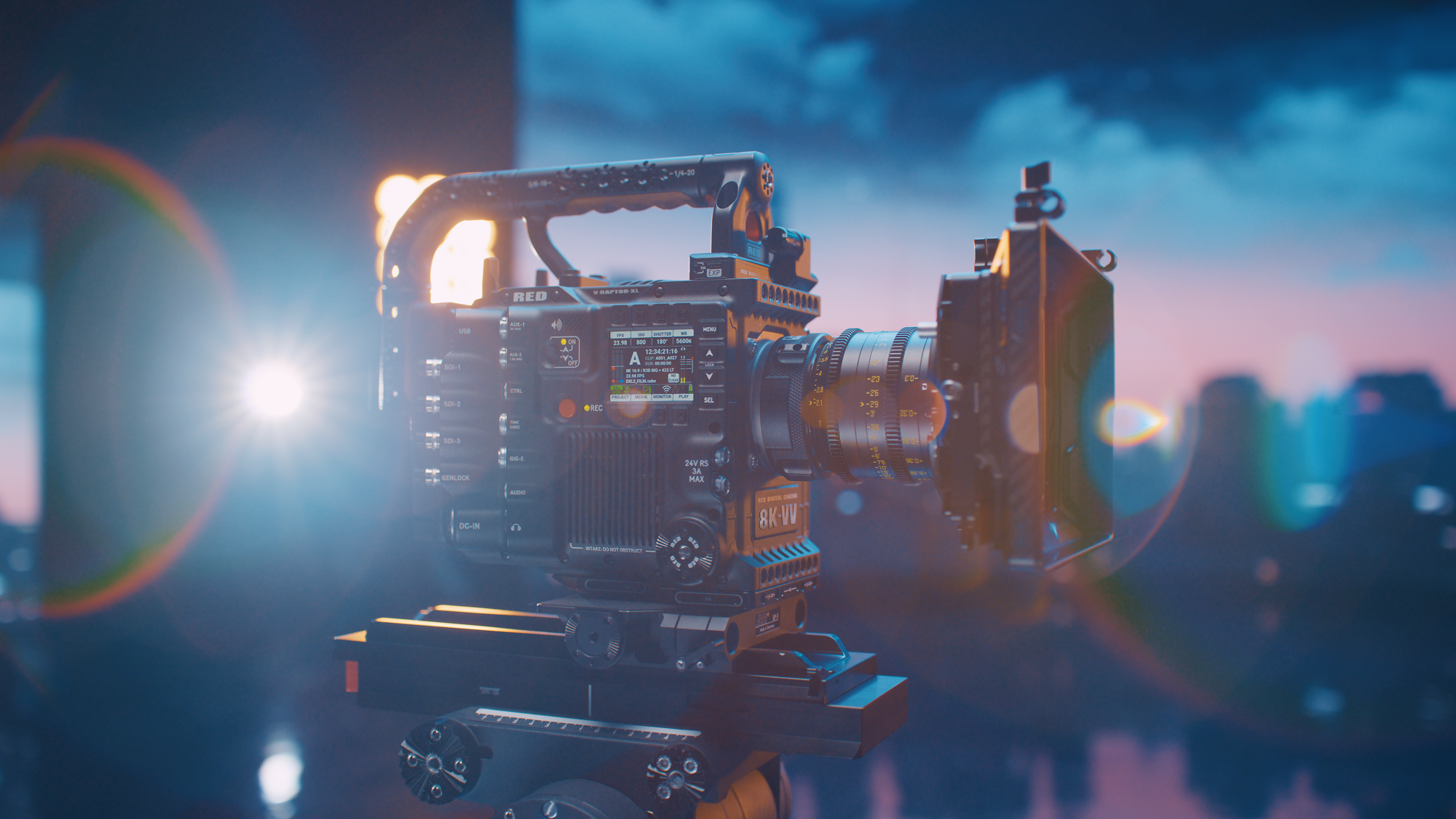 A professional cinema camera with various controls and a large lens, set against a colorful dusk sky with clouds and cityscape in the background.
