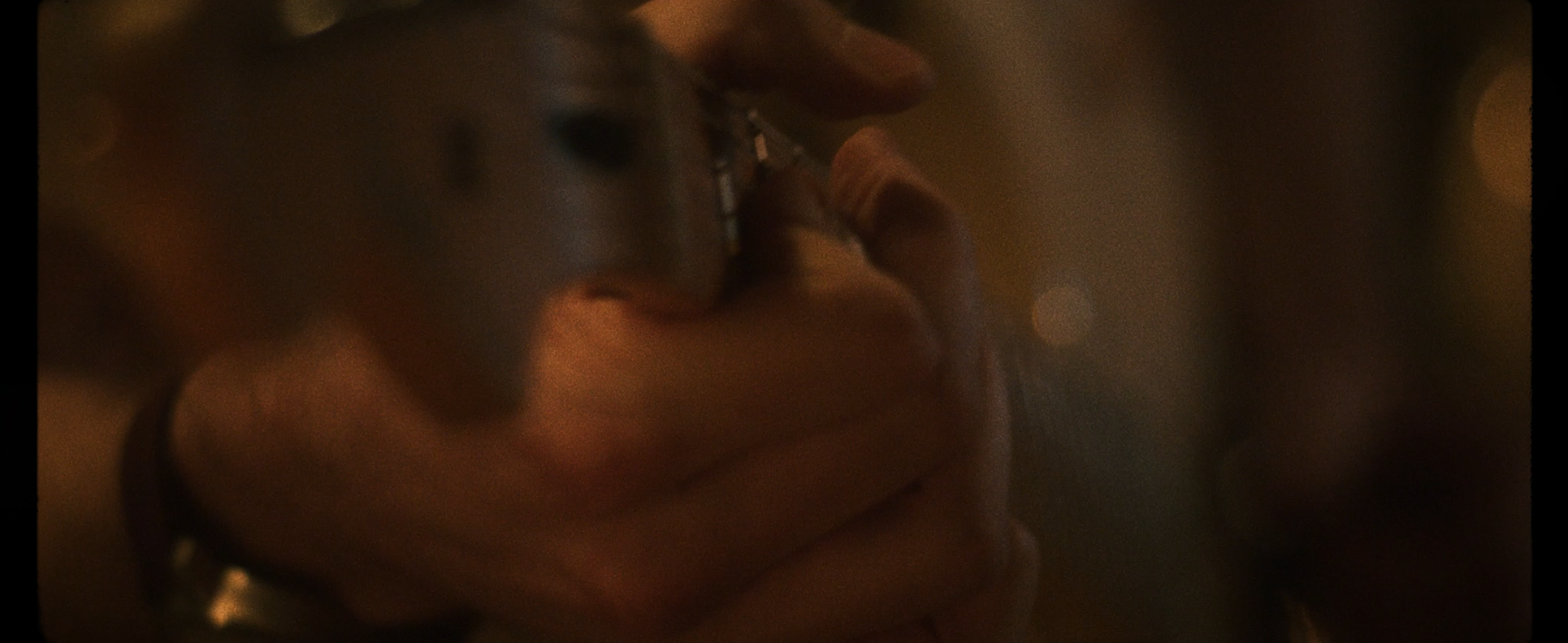 Close-up of two people drinking from shot glasses, holding small glasses near their mouths in a dark, intimate setting.