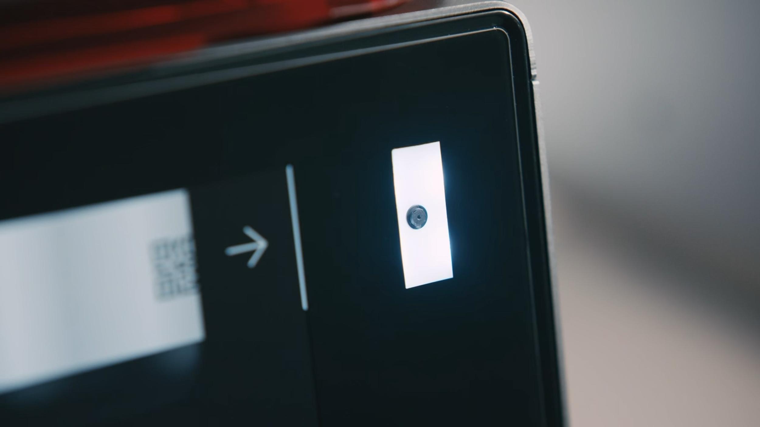 Close-up of an elevator control panel with a lit button indicating the direction to go up.