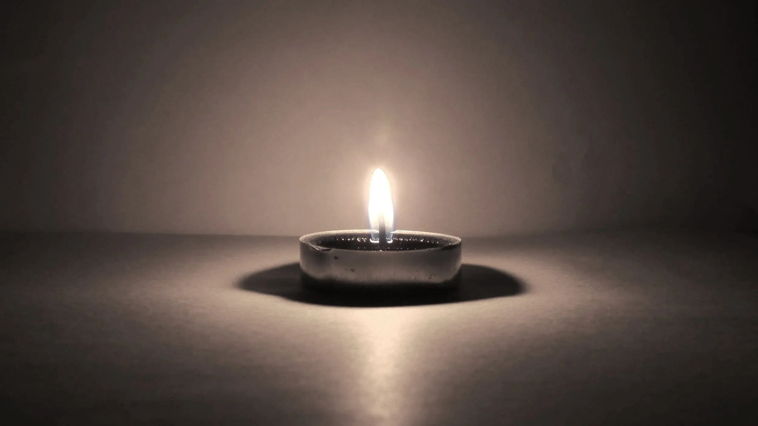 Single lit tea light candle