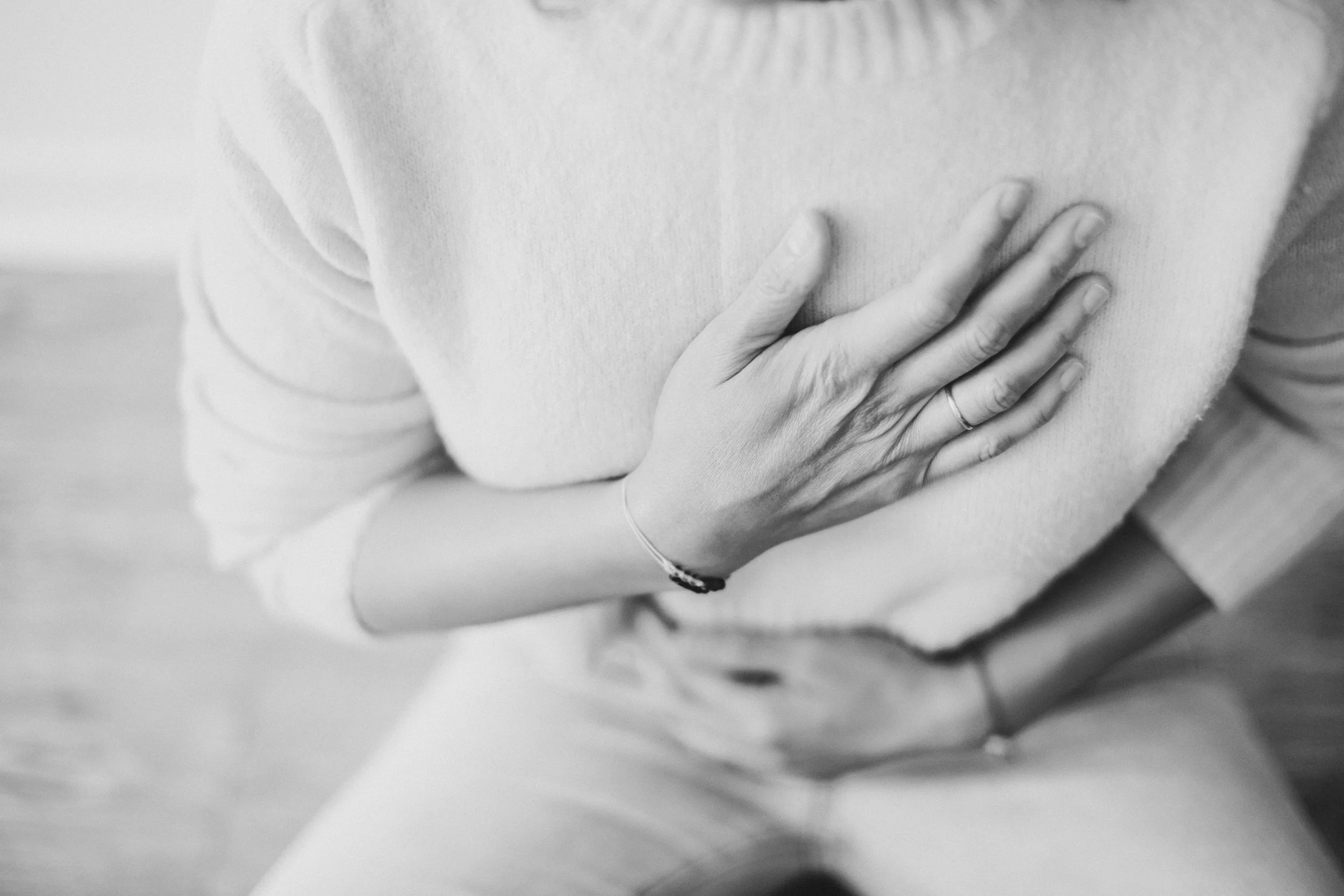 woman holding her chest with hands and breathing deeply