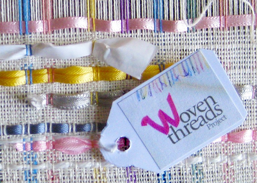 Woven cloth with Woven Threads Project logo