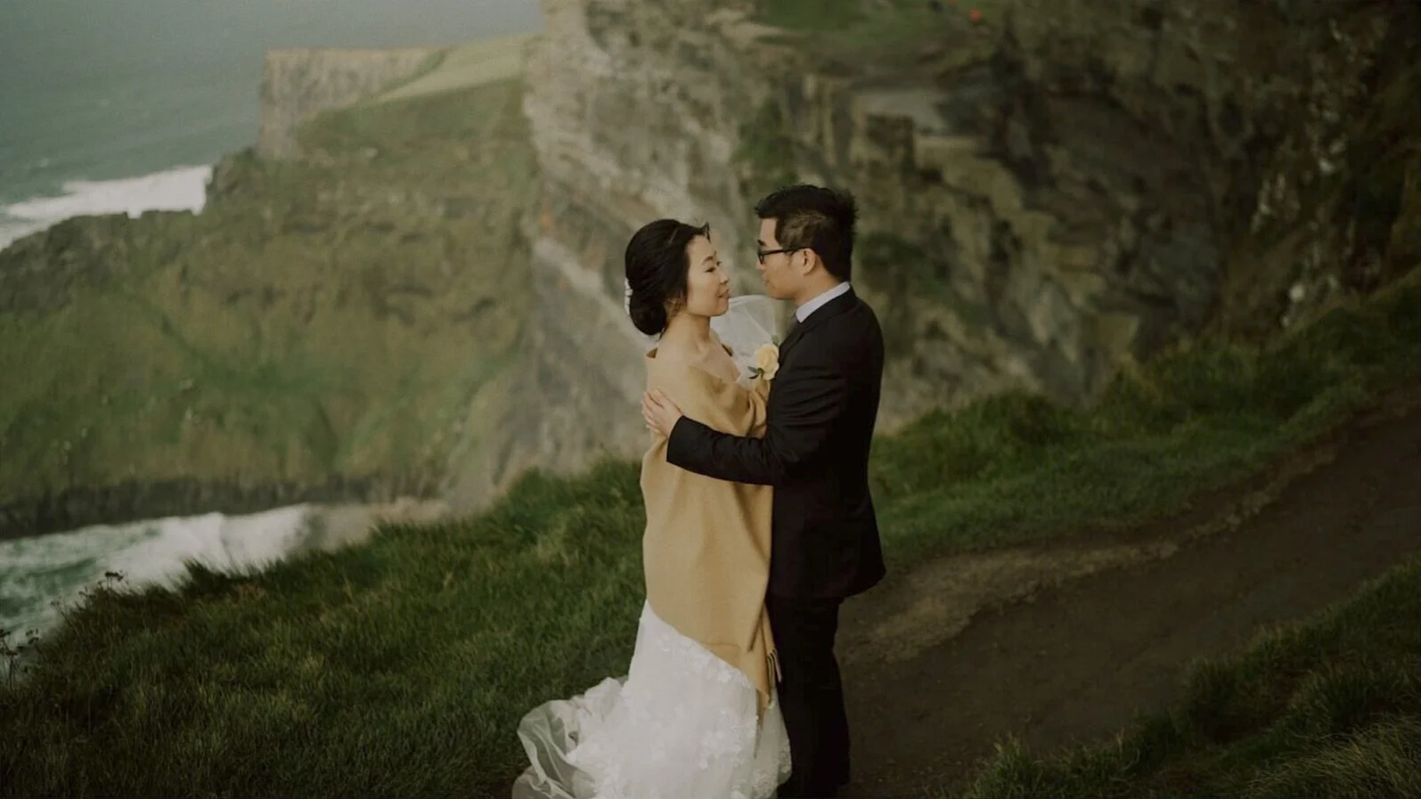 Couple surrounded by the dramatic Atlantic landscape at the Cliffs of Moher
