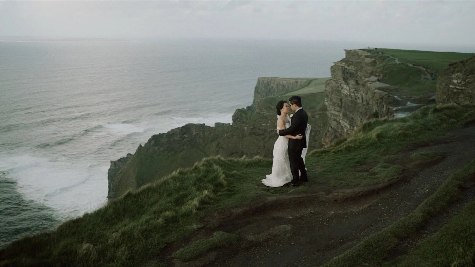 Anqi and Shihao exploring the cliffs with the Atlantic sea stack in the background