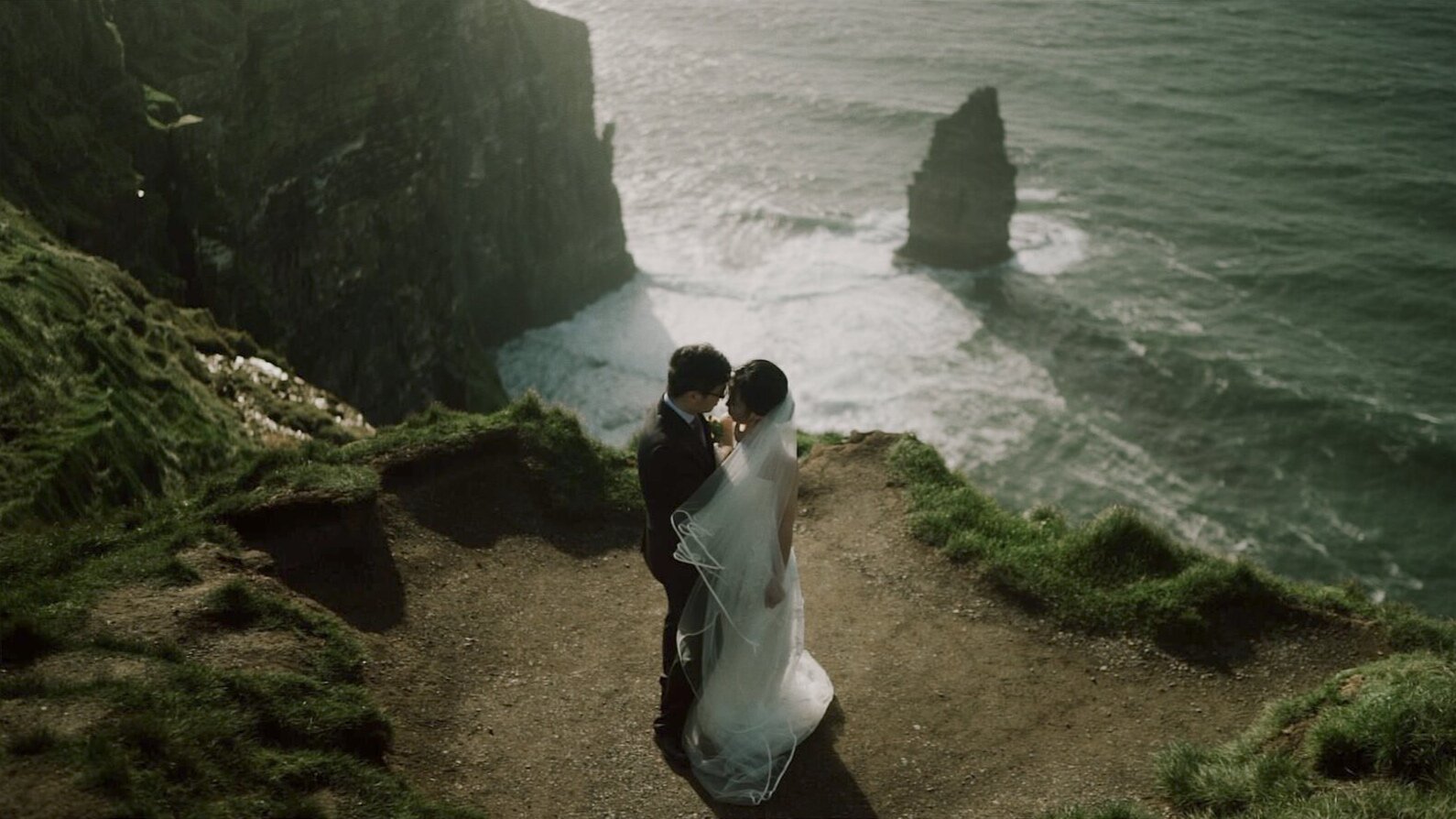 Couple embracing above the Atlantic Ocean during their Cliffs of Moher elopement