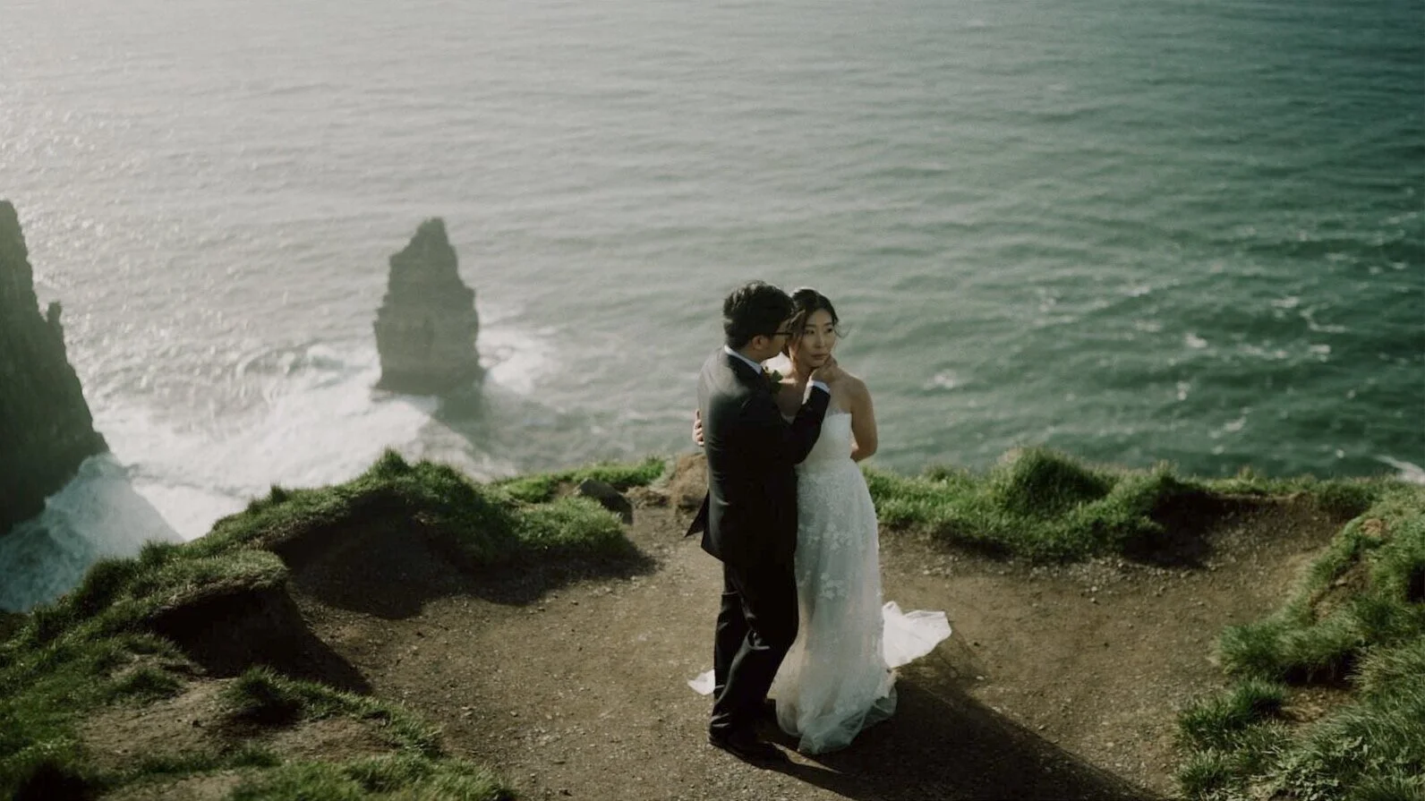 Wide view of an elopement couple surrounded by the Cliffs of Moher landscape