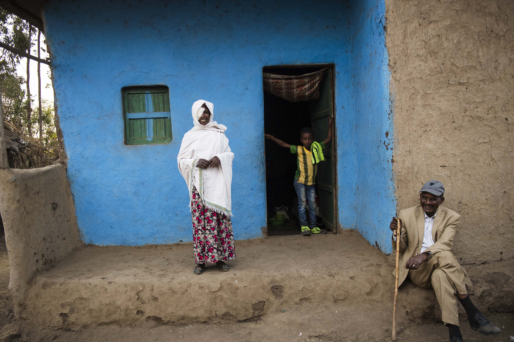  Asnaku Tufa stands outside her home after receiving corrective eye surgery for Trachomatous Trichiasis (TT) at a local clinic.   
