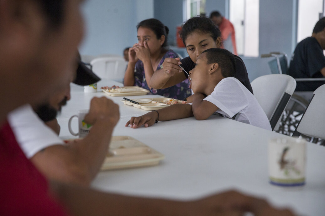 Families, who are waiting to cross the border, seek shelter at Senda De Vida Casa Del Emigrante, on Wednesday, June 20, 2018, in the border town of Reynosa, Mexico. Patricia Flores, 27, feeds her son, Joan, 7, in the centers dormitory. Patrica said