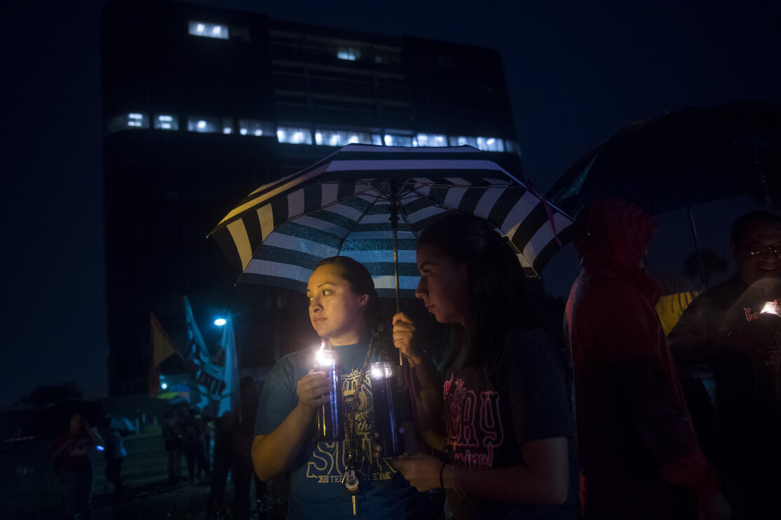 Selena Medina, 23, left, and Josie Sloss, 20, right, attend a vigil and prayer walk on Wednesday, June 20, 2018, in McAllen, TX. Participants walked from Archer Park to the federal courthouse a few blocks away, in honor of immigrant families and chi