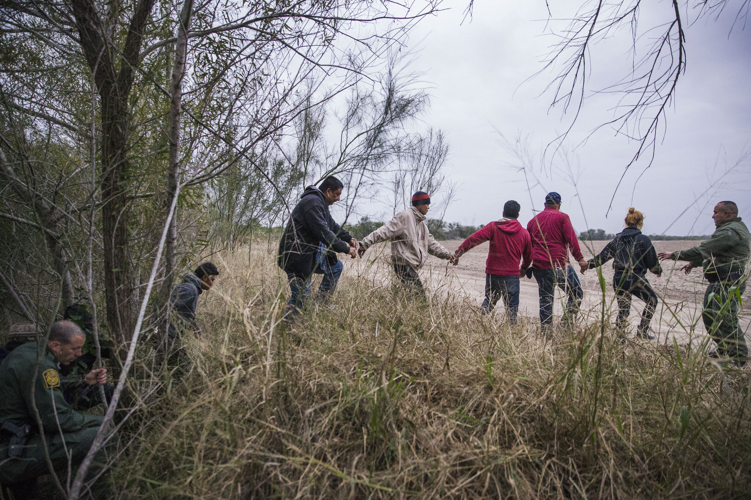  Border Patrol Agents lead a group of immigrants out of the brush after they were apprehended crossing the border from Mexico into the U.S. on Wednesday, Dec. 5, 2018, near McAllen, TX. 
