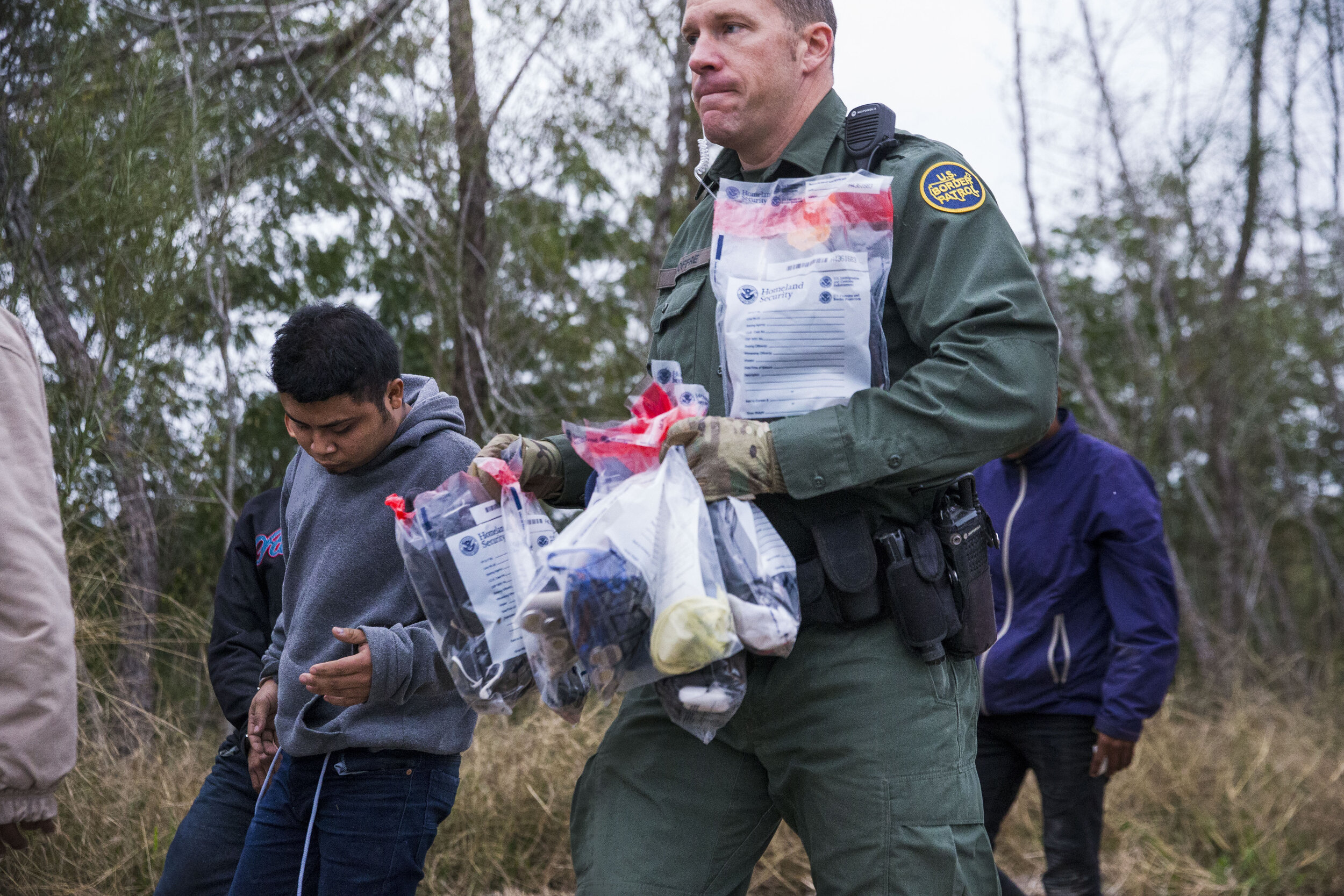  Border Patrol Agent Mark Joffre carries the belongings of a group of immigrants suspected of illegally crossing the border from Mexico into the U.S., while they were being taken into custody on Wednesday, Dec. 5, 2018, near McAllen, TX. 