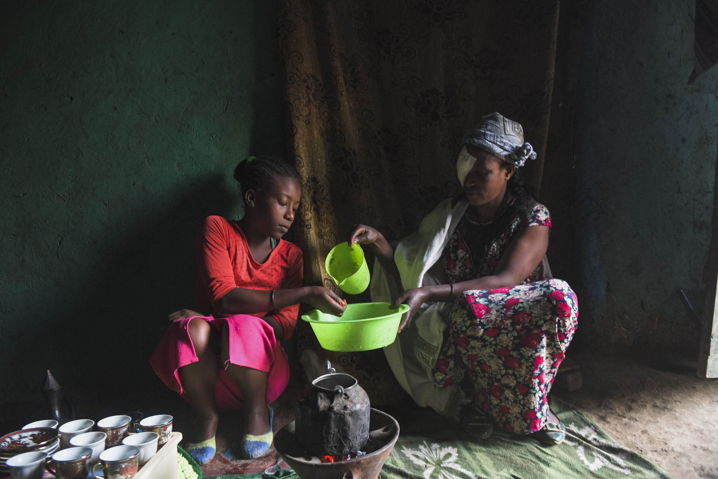  Asnaku Tufa washes dishes with her daughter while at home after having corrective surgery for Trachomatous Trichiasis (TT). During the testing Tufa was informed that TT is not a hereditary disease and that the precautions she has been taking at home