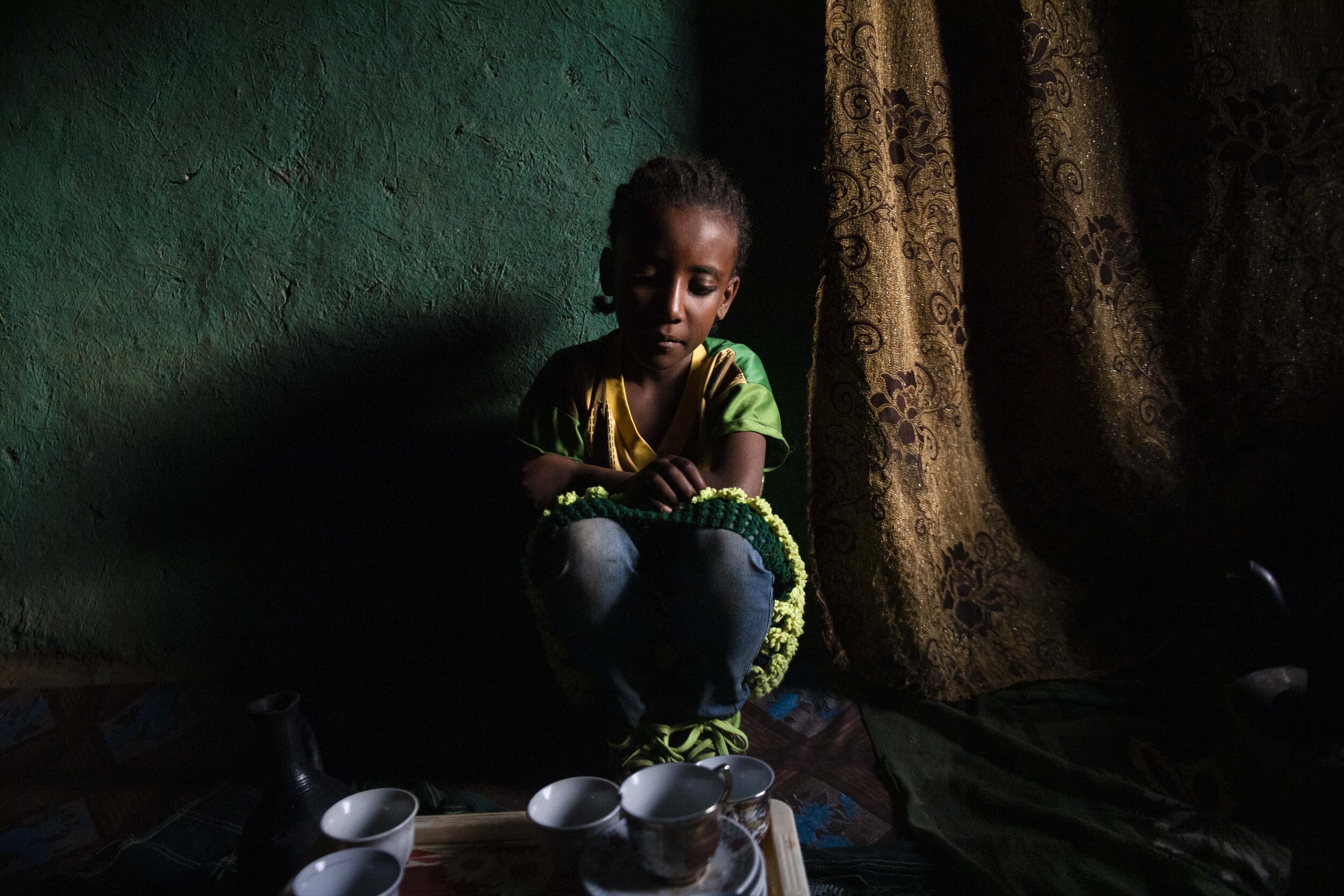  Asnaku Tufa’s youngest daughter helps prepare coffee.  As a child, Asnaku would watch as her mother epilated her lashes to relieve the pain from the Neglected Tropical Disease, Trachoma, which causes the turning in of eye lashes.  