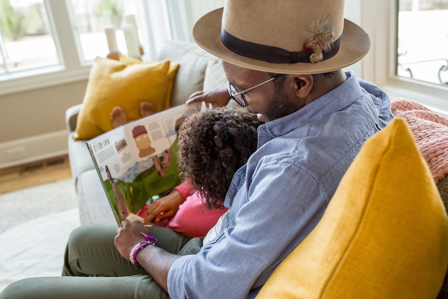 Foster father reads to young girl.