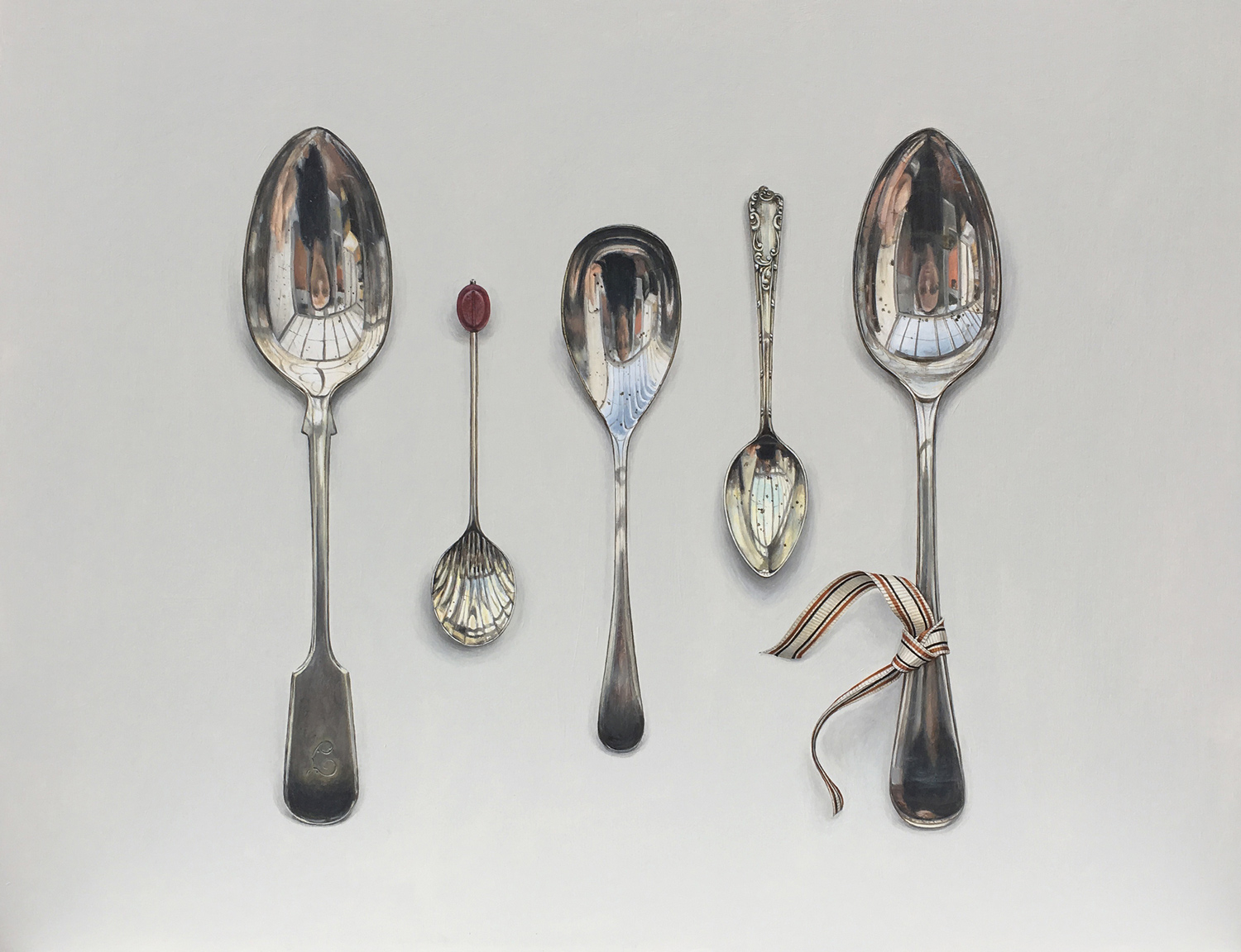 arranged spoons with striped ribbon