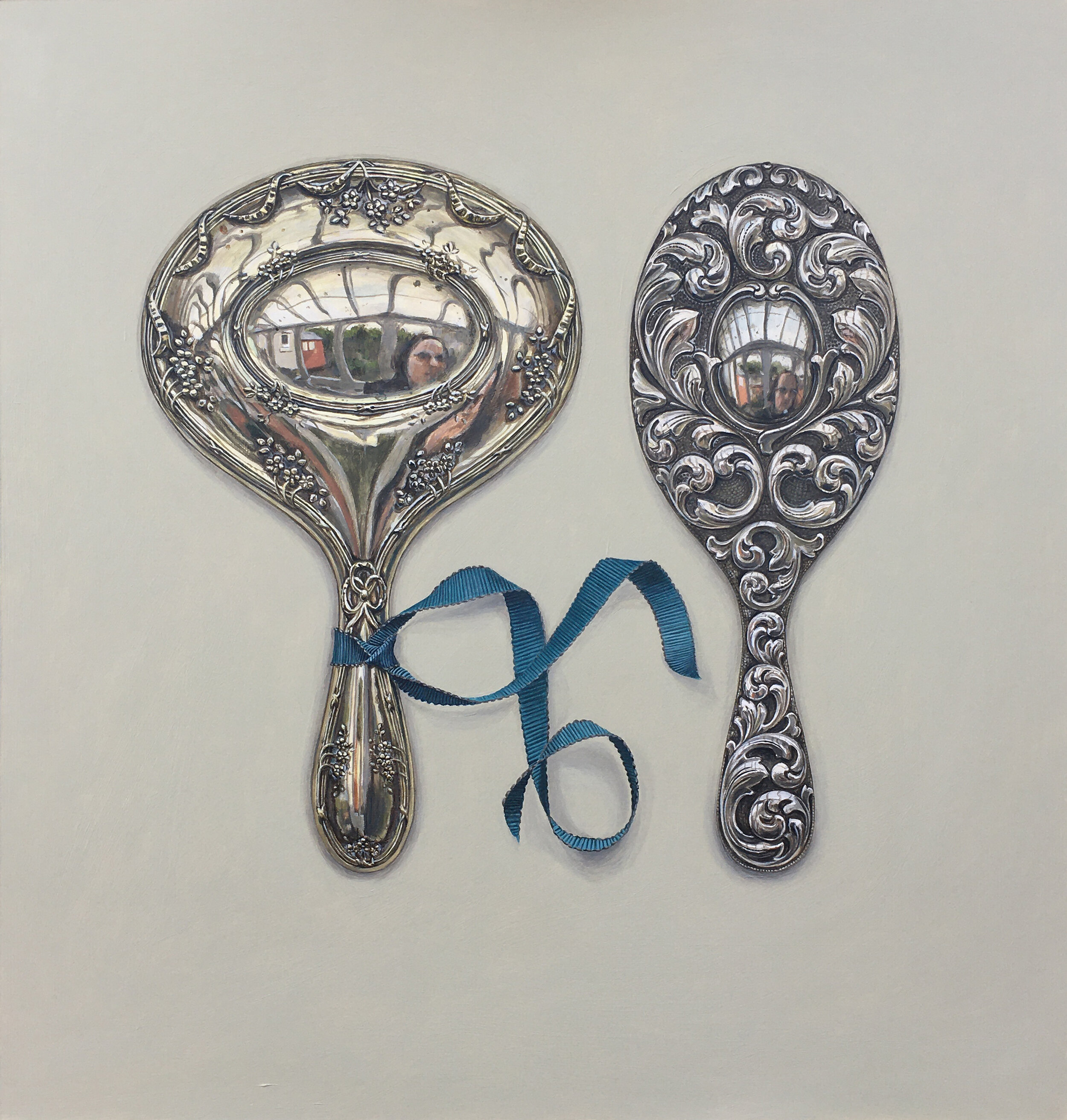 two silver mirrors with blue ribbon