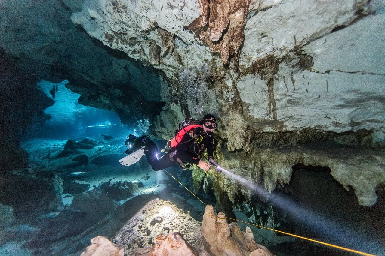 scuba diver entering a cavern section at dos ojos