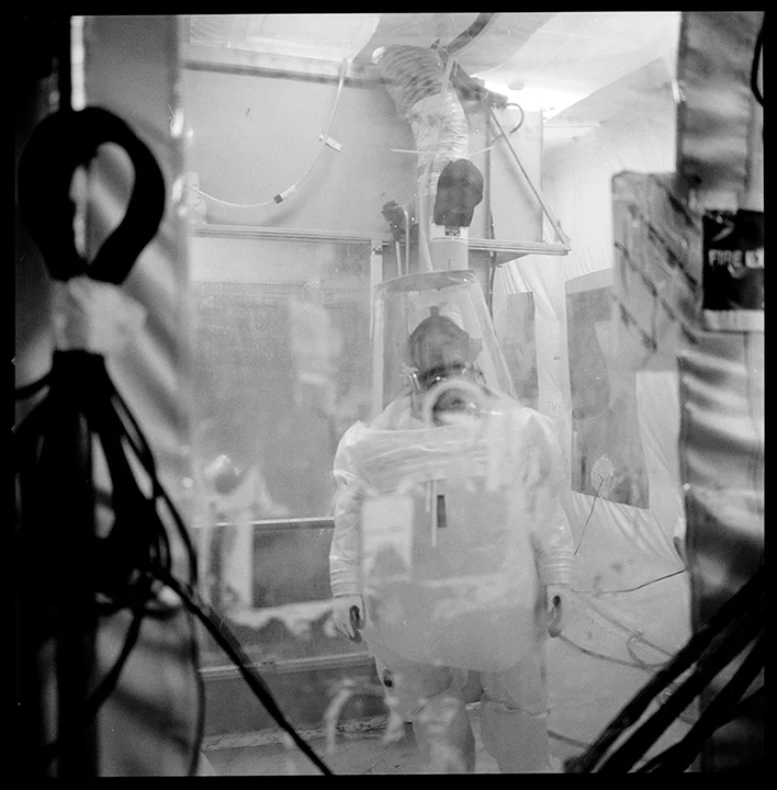 183 Reduction Tent, RFETS, 2001 A worker can be seen inside a supplied air bubble suit through a plastic window in the tent. The tent was used to cut up contaminated machinery and glove boxes to fit in disposal boxes. In 2001, several workers inhaled plutonium particles after an air filter alarm failed.