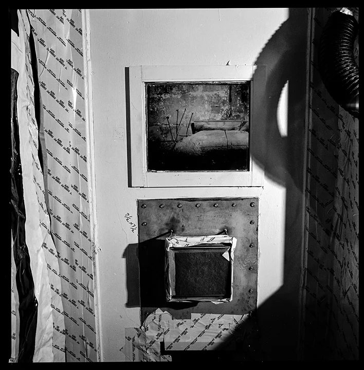 Door to “Infinity Room”, Building 771, RFETS, 2003 Building 771 had several “infinity rooms”, or rooms so contaminated with plutonium and other radioactive isotopes that the radiation exceeded the capacity of the Geiger counter to measure. These rooms were sealed off for years before the demolition activity required their cleanup and removal. Many were simply cut out of the building structure and shipped away for disposal or burial at a nuclear waste repository site. ( Full disclosure: In this one image, I have composited the scene from inside the room taken through the window into the window area of the door.)