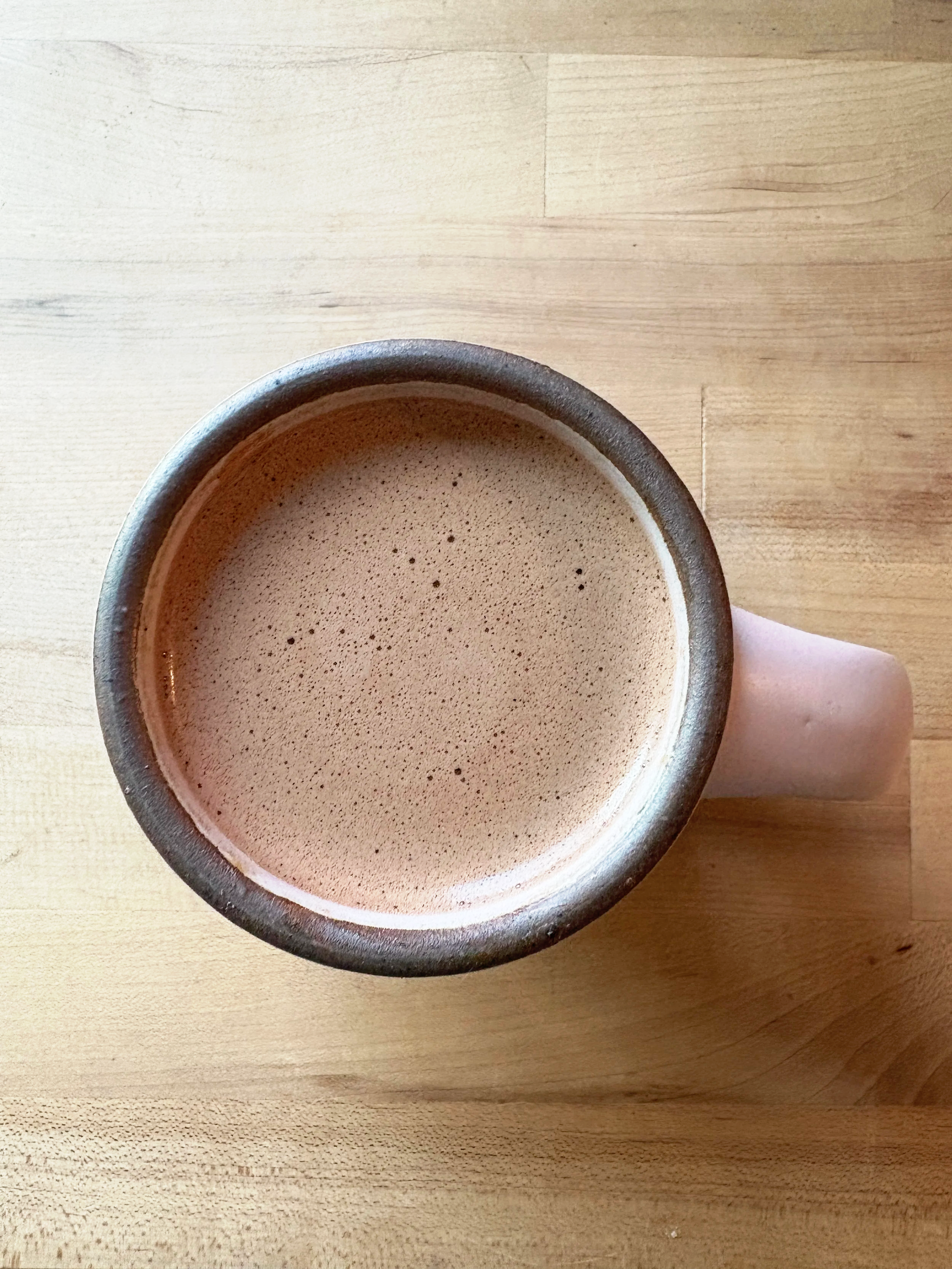 Pink pottery mug with hot beverage