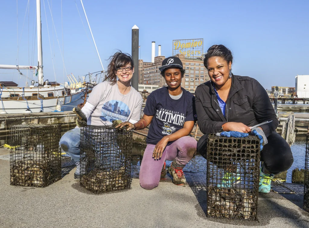 Tammy Dexter, Lanae Jackson and Carmera Thomas clean oyster cages. Photo from Baltimore Style magazine.