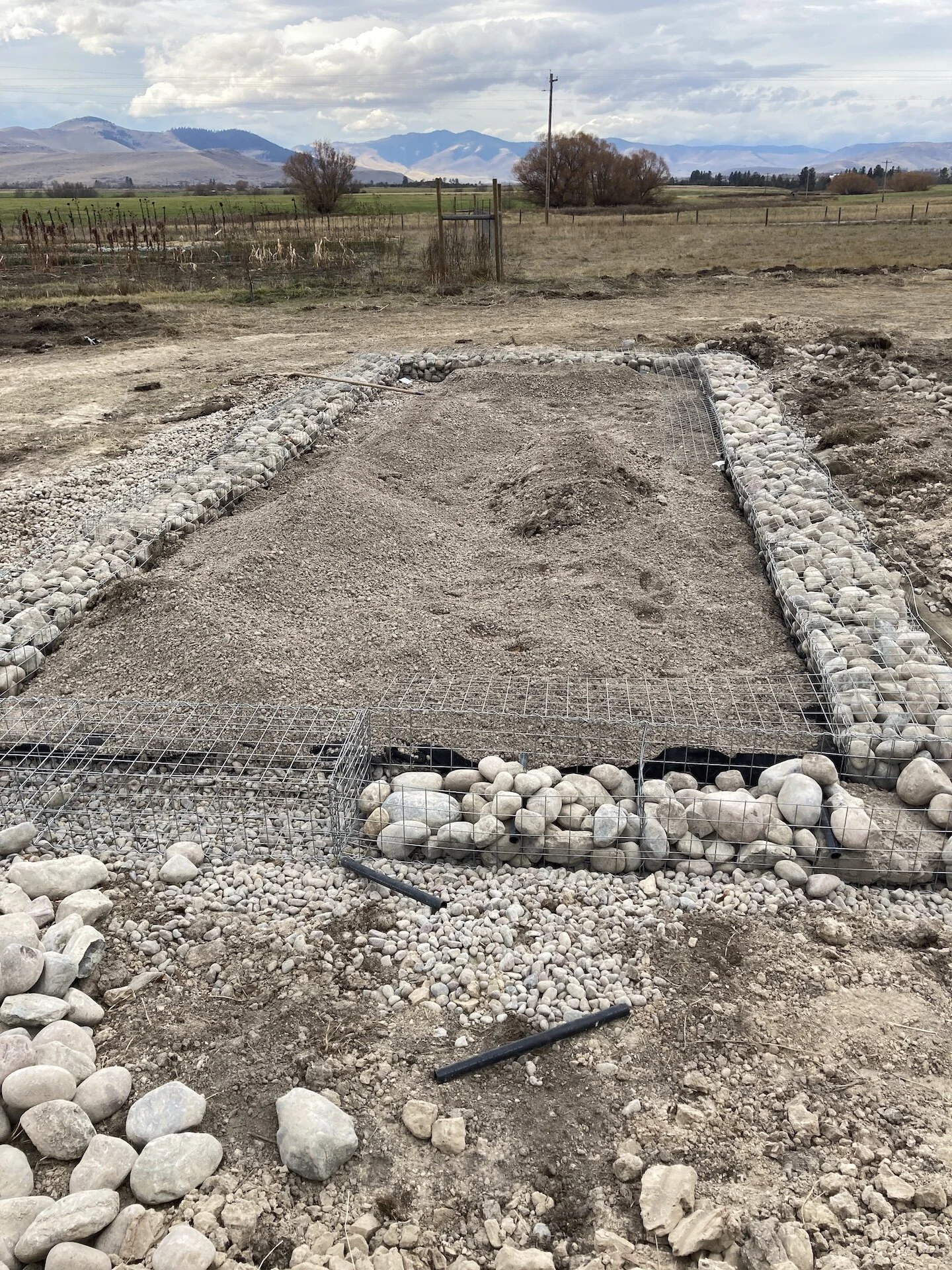  Filling the gabions in sections.  1” poly pipe sections were put into the rock to accept compression wires later in the process.   