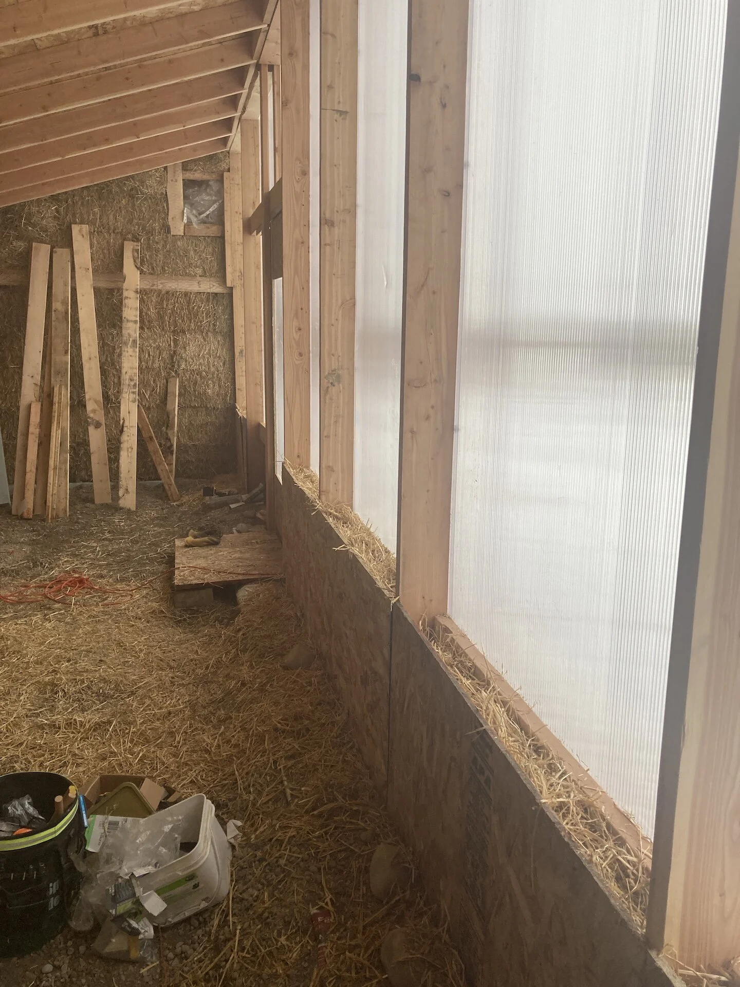  With the structure mostly built and sealed up for winter, it was time to turn attentions to the inside.  Here I insulated the window bases with loose straw.   