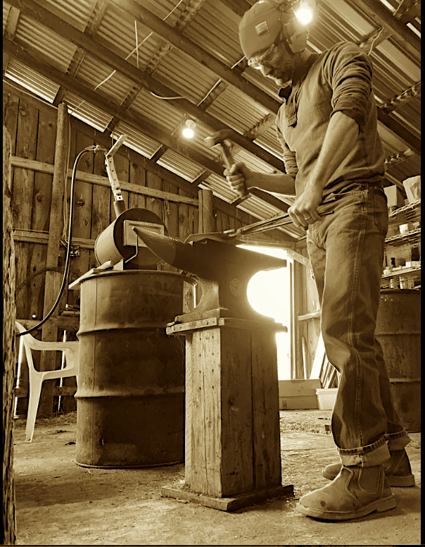 Zach Seligman forging a kitchen knife in his western Montana Blacksmith shop