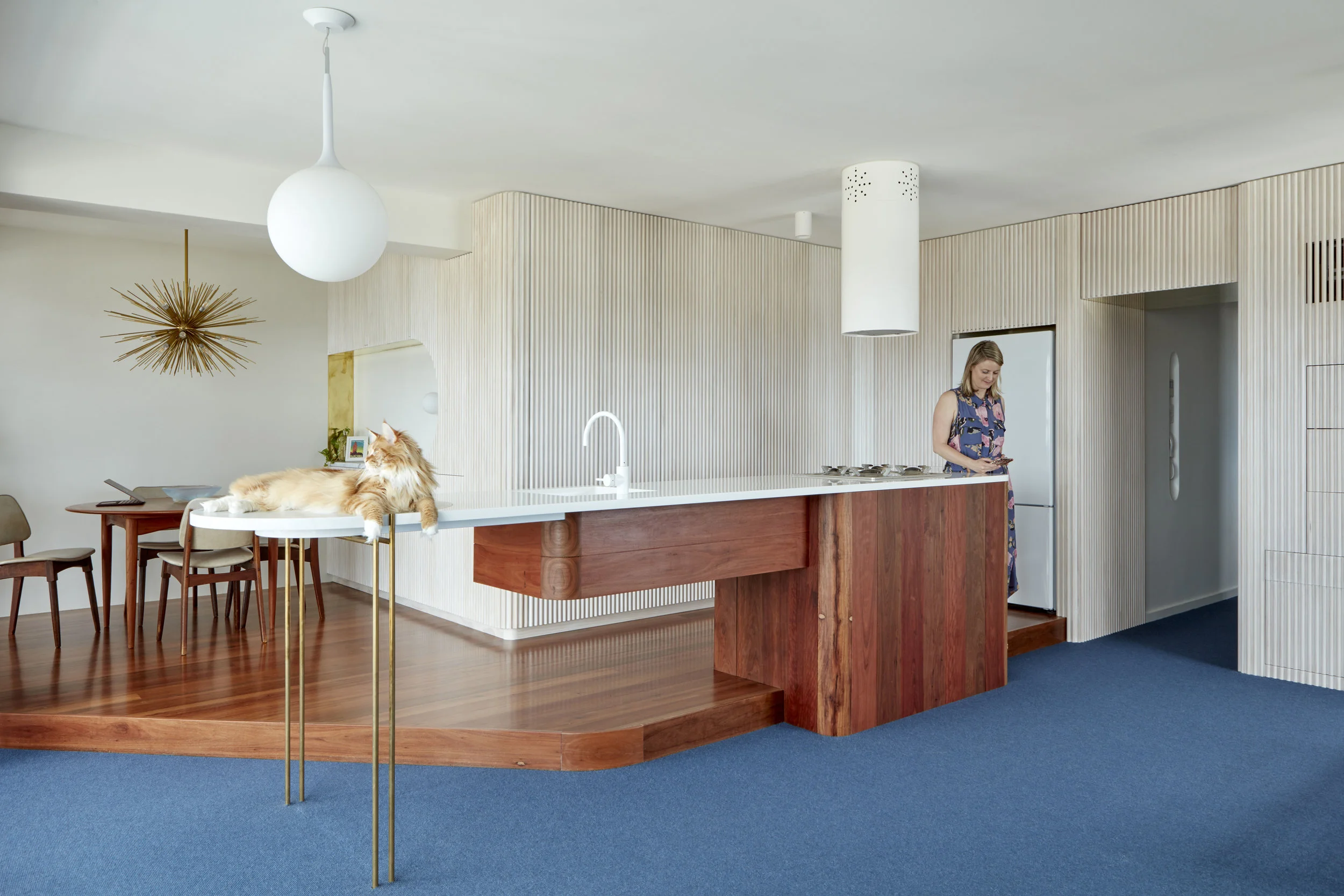 Torbreck Apartment Renovation - Tom lounging on the bar taking in the view. Notice how the island bench transitions from normal kitchen bench height on the timber plinth to standing bar height at the end? This small change creates designated ‘zones’ in an open plan apartment. The bar end is detailed with a circular marble piece that Tom is lying on (recycled from the old kitchen) this minor details create a special feeling that defines the kitchen from the bar. It also creates a nice relationship to the dining/cocktail making area, allowing standing height guests to be at eye height to those sitting down.
