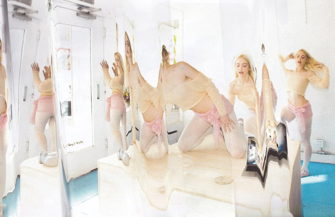 A group of women with blonde hair, dressed in light-colored tops and pink bottoms, are posing in front of a reflective, wavy mirror in a bright room.