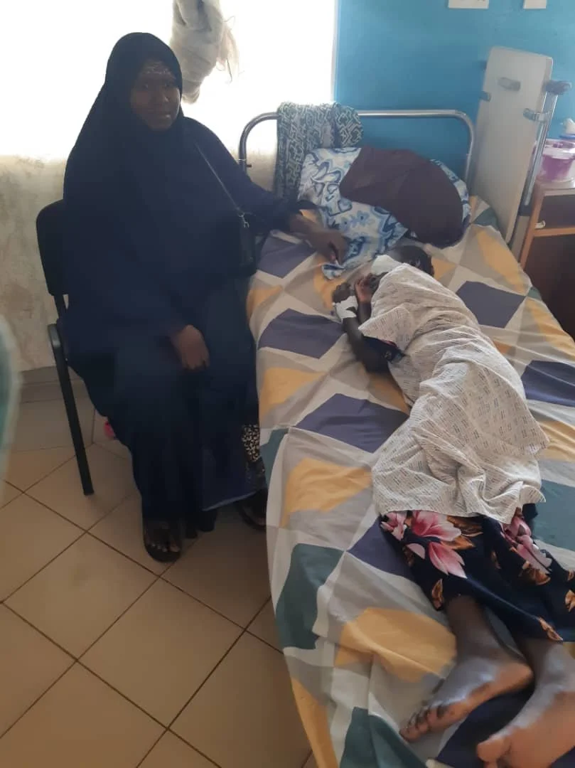 Arabi Drammeh recovering from anasthetic with mum.jpg