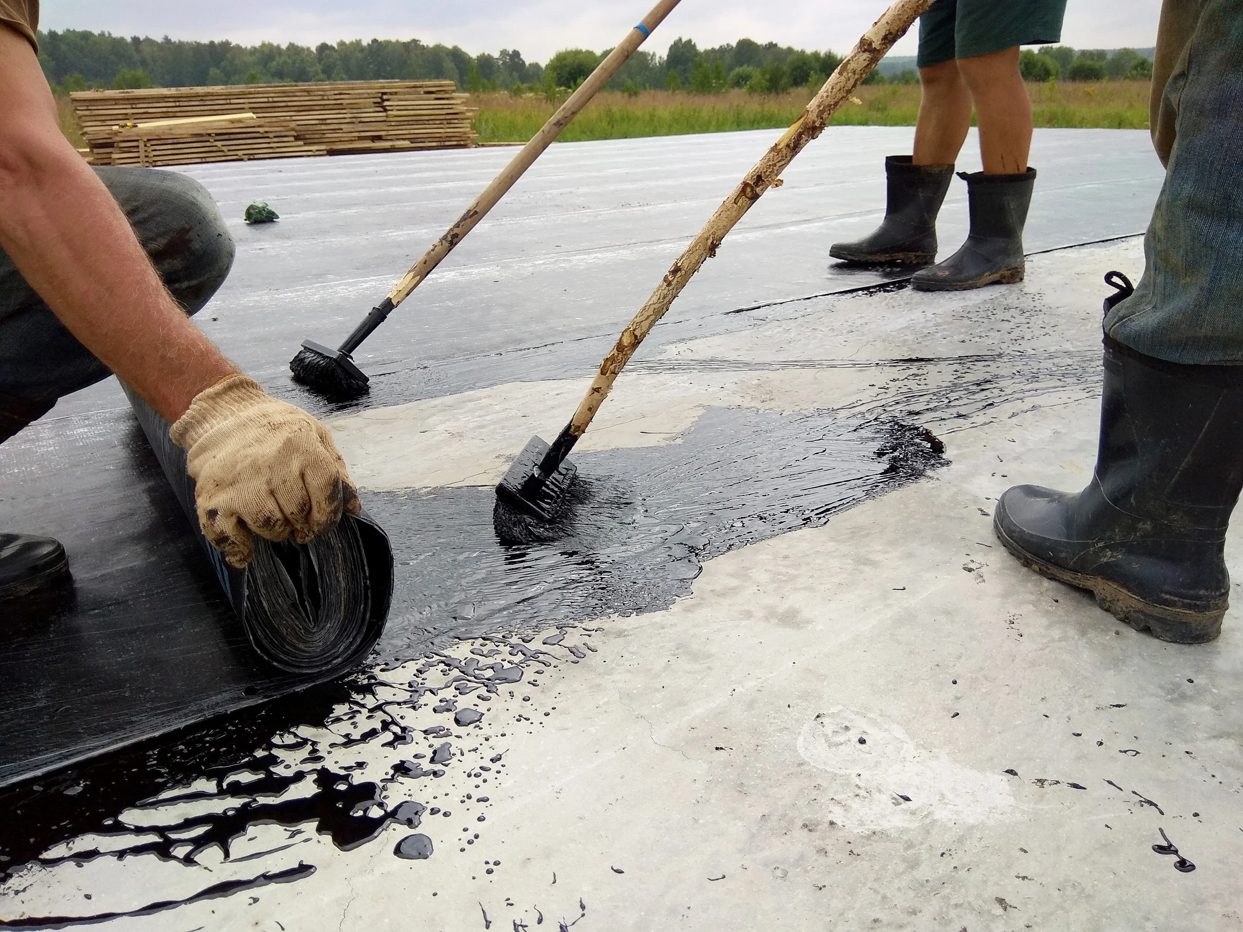 096082522-roofer-worker-painting-bitumen.jpeg