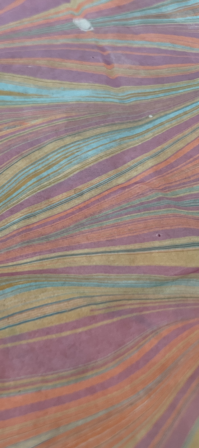 Close-up of colorful striped fabric with wavy lines in shades of purple, pink, blue, green, and orange.
