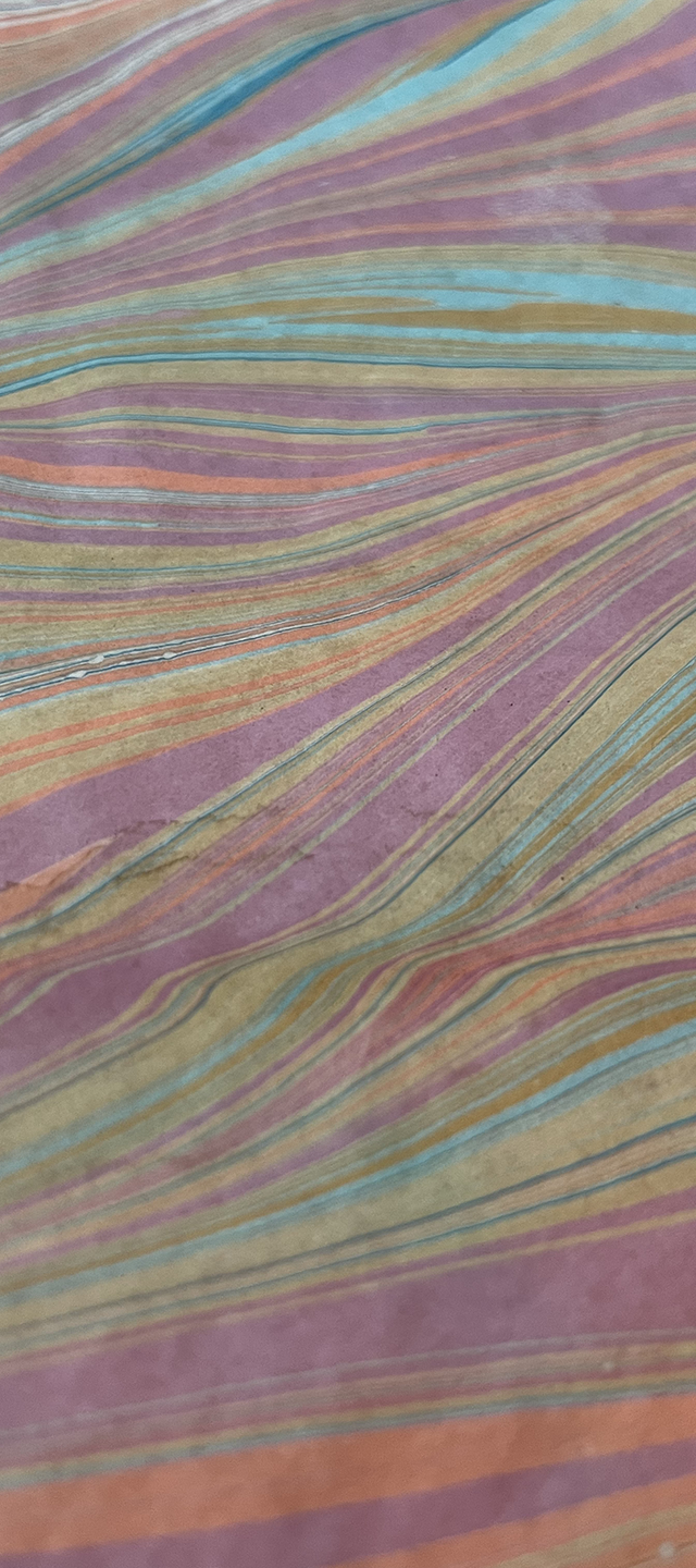 Close-up of a multicolored, striped fabric with wavy lines in pastel shades of purple, pink, blue, green, yellow, and orange.