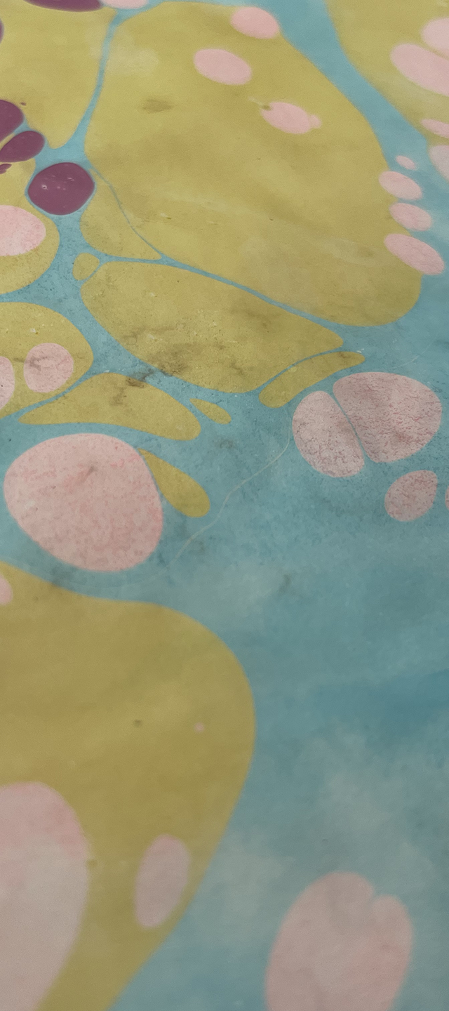 Close-up of a colorful, abstract pattern with large yellow and pink shapes on a blue background.
